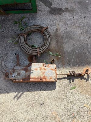 a rusted metal object on the ground next to a hose