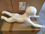 a white mannequin laying on top of a cardboard box
