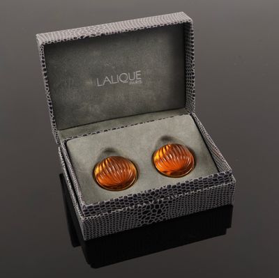 pair of orange glass cufflinks in a gift box on a black surface