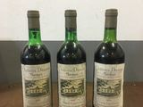trois bouteilles de vin posées sur une table l'une à côté de l'autre