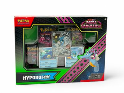 a box of pokemon cards with a keychain on top of it