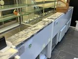 a counter with a glass display case and a basket on top of it