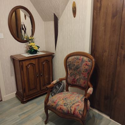 a chair that is sitting in a room with a mirror on the wall