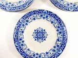 three blue and white plates with designs on them sitting on a table