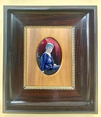 an old picture of a woman in a blue dress in a wooden frame