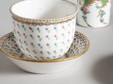 two cups and a saucer sitting on a table