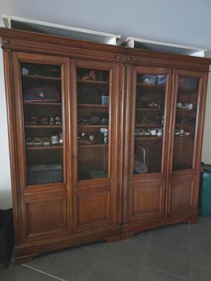 un grand meuble en bois avec des portes en verre dans une pièce