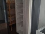 a refrigerator in the corner of a room with a door open
