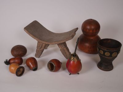 un petit tabouret en bois, un bol et d'autres objets posés sur une table