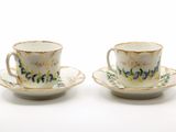 deux tasses et soucoupes ornées de motifs floraux sur un fond blanc