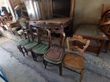 plusieurs chaises et une table dans une pièce avec beaucoup de meubles