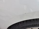 the tire of a white car with a black sticker on it