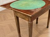 une table recouverte d'un tissu vert, placée au milieu d'une pièce
