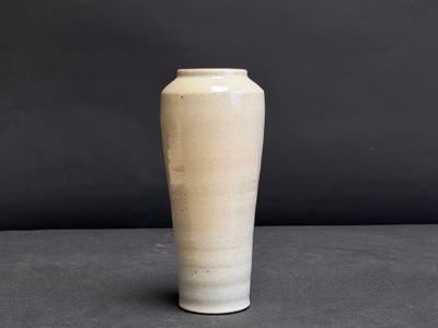 a white vase sitting on a table with a black background