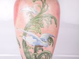 un vase rose orné d'une peinture représentant des oiseaux