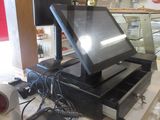 une photo représentant une caisse enregistreuse et un ordinateur portable posés sur un comptoir