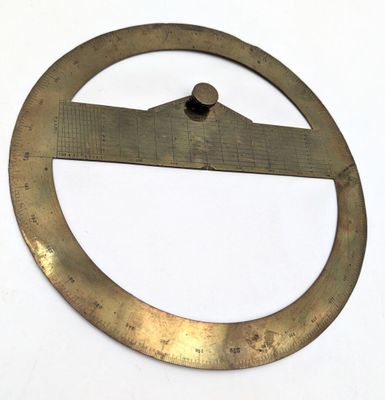 un cercle métallique contenant une règle, posé sur une surface blanche