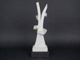 a white sculpture on a black surface with a black background