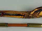 a wooden pipe and a brass pipe holder next to each other