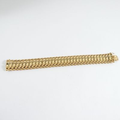 a gold bracelet on a white background
