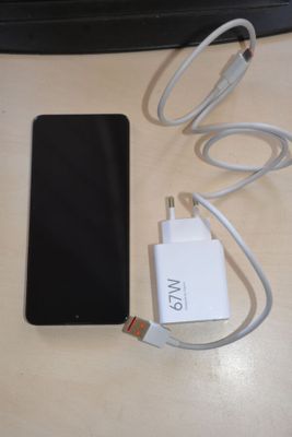 a cell phone and a charger sitting on a table