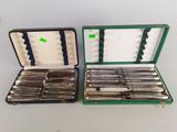 two silverwares in a green case on a table