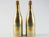 two bottles of champagne sitting next to each other on a white surface