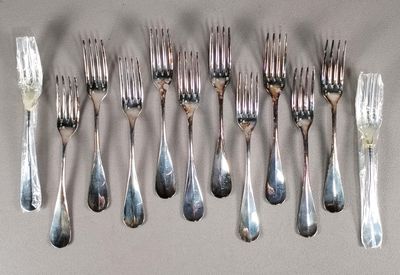 Plusieurs fourchettes et cuillères sont disposées en rangée sur une table