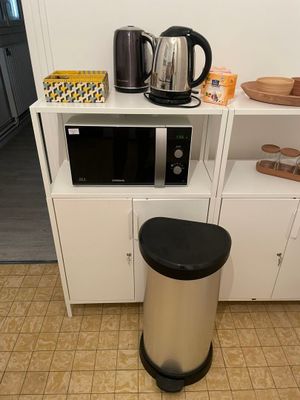 un micro-ondes et une poubelle dans la cuisine