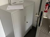 a white cabinet with a fire extinguisor on top of it
