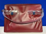 une photo d'un sac à main rouge avec des anses transparentes posé sur une table