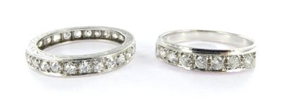 two wedding bands with diamonds on them on a white surface