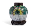 un vase vert orné de fleurs, posé sur un socle