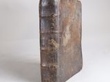an old book sitting on top of a white table next to a white wall