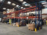 L'entrepôt est rempli de cartons empilés sur les rayonnages.