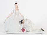 une figurine représentant un couple de jeunes mariés allongés par terre