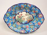 une assiette bleue décorée de fleurs et d'oiseaux