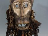 an image of a mask on a stand with a tag on it