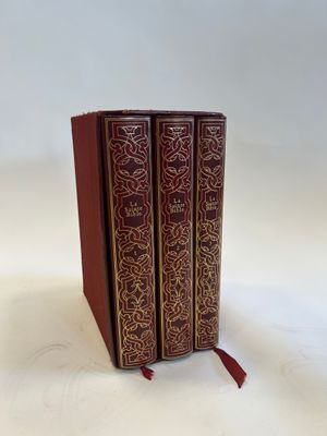 two red books sitting on top of each other on a white surface