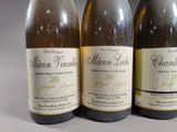 three bottles of wine are lined up on a table