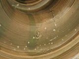 a close up of a brass vase on a white surface