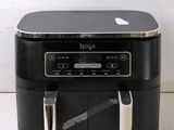 a black and silver air fryer sitting on a counter