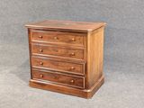 une petite commode en bois sur fond gris