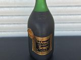 une bouteille d'alcool posée sur une table près d'un mur