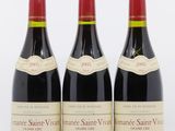 trois bouteilles de vin rouge posées l'une à côté de l'autre sur une surface blanche