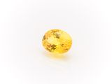 a yellow sapphire stone on a white background