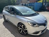 La voiture argentée est garée sur le parking, à côté d'un immeuble.