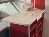 un bureau sur lequel se trouve une lampe, dans une pièce