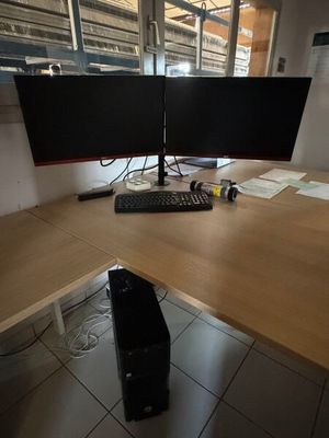 deux écrans d'ordinateur posés sur un bureau en bois