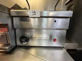 a silver oven sitting on a counter in a kitchen